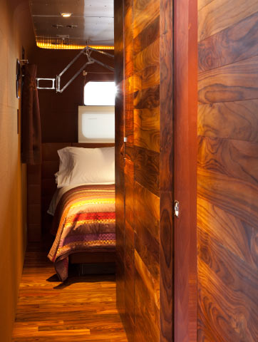 Floors and wall panels of reclaimed rosewood create a warm counterpoint to the trailer’s metal exterior. Missoni blanket from Pat McGann.