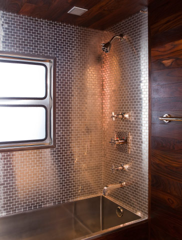 The bathroom features steel tiles from Ann Sacks and, left, hardware by Antonio Citterio for Hansgrohe.